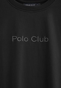 Svart sweatshirt med rund hals i mjukt tyg, med präglad "Polo Club"-logotyp på framsidan, med en slät textur och minimalistisk design.