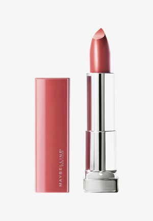 Maybelline lippenstift in een cilindrische zilveren tube met een lichtroze-nude bullet, die een gladde afwerking en subtiele glans toont.