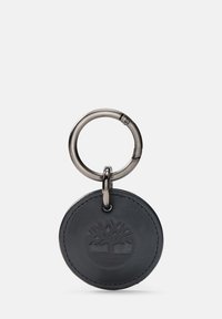 Okrągły, czarny skórzany brelok do kluczy z wytłoczonym logo drzewa, przymocowany do metalowego kółka w kolorze srebrnym, o gładkiej fakturze i przeszytych brzegach.