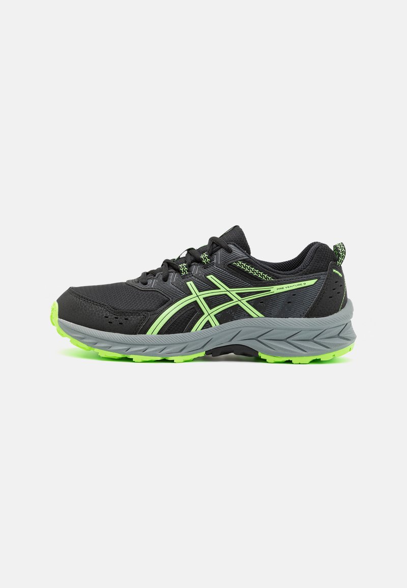 Zapatillas deportivas negras con suela gris y acentos en verde neón. Parte superior de malla con un acabado texturizado y diseño tradicional de cordones.