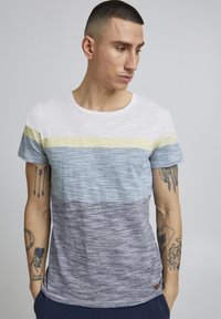 Camiseta de manga corta con rayas horizontales en blanco, amarillo, azul y gris. Textura suave con un clásico cuello redondo.