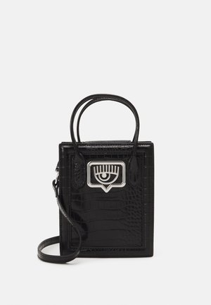 Zwarte rechthoekige handtas met krokodillentextuur, twee afgeronde handvatten, afneembare schouderriem en zilverkleurige metalen sluiting in de vorm van een oog aan de voorkant.