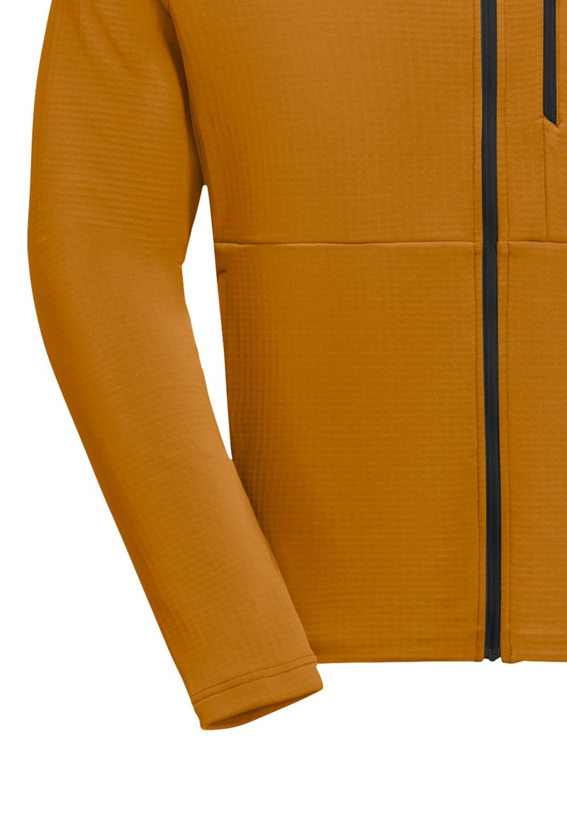 Veste zippée orange avec une surface texturée, dotée de manches longues et d'une fermeture éclair à l'avant. Comprend une poche sur la poitrine.