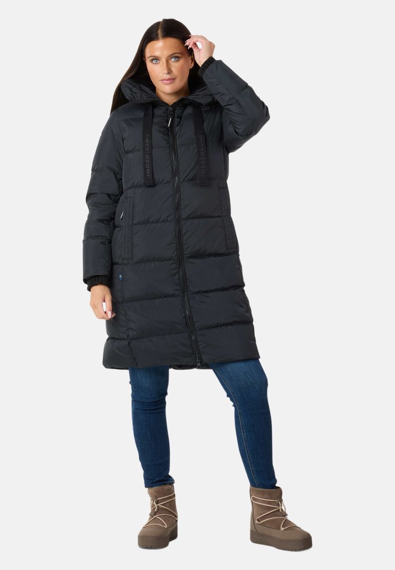 Cappotto invernale nero con cuciture orizzontali, collo alto e zip frontale. Dotato di coulisse sul cappuccio e spalline con logo.