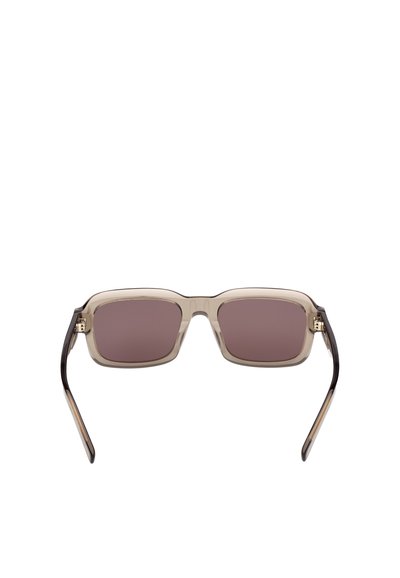 Gafas de sol cuadradas con montura transparente y lentes con tintado marrón. Las varillas presentan un degradado de transparente a marrón oscuro. Acentos dorados cerca de las bisagras.