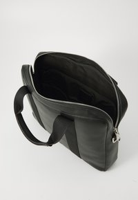 Schwarze Lederaktentasche mit Reißverschluss, weichen Stoffgriffen und einem unlinierten Innenraum, der mehrere Fächer zeigt. Glatte Textur, strukturiertes Design.