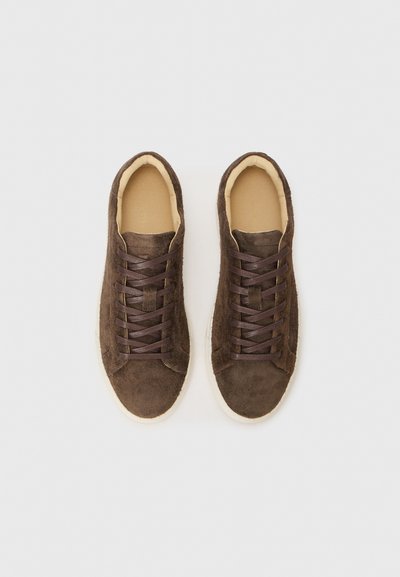Brown suede sneakers with dark brown laces, rounded toe, and beige sole. Smooth interior lining, minimalistic design with no patterns or accents.