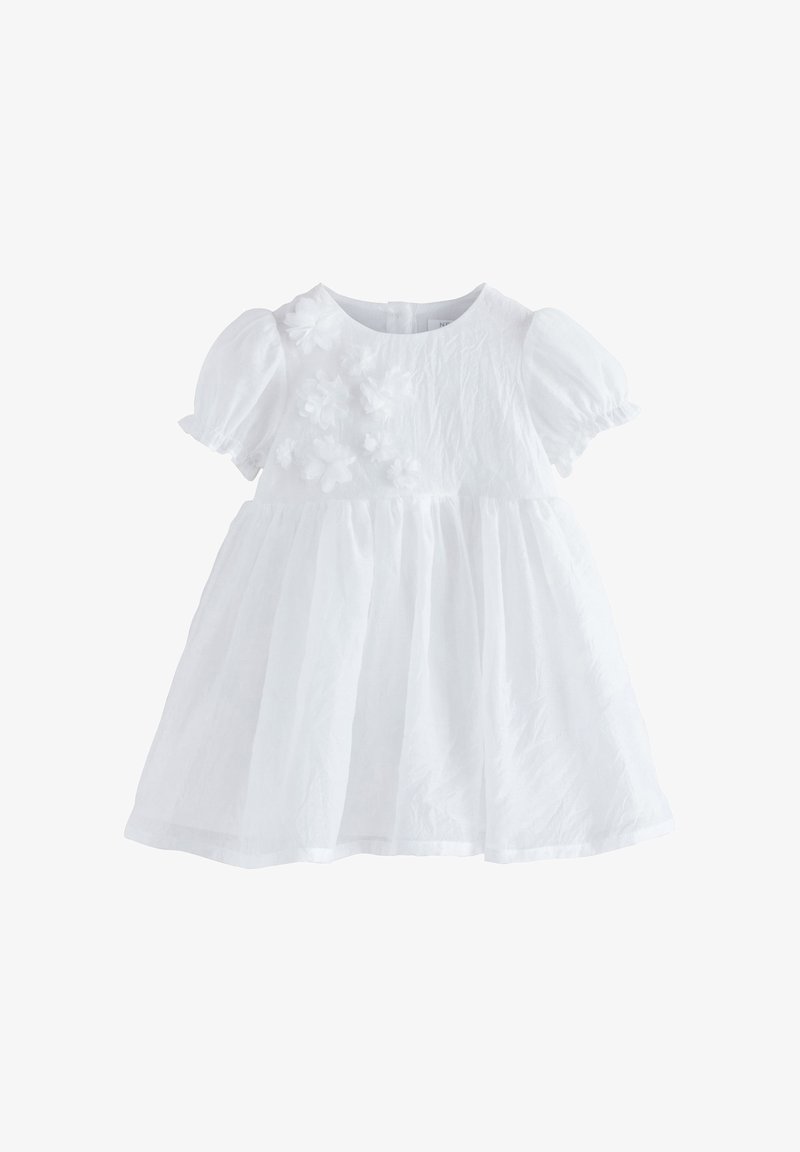 Robe blanche pour bébé avec manches bouffantes et appliqué floral sur la poitrine, taille froncée et col rond.
