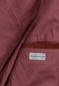 Bordo tkanina glatke teksture, s etiketom na kojoj piše "Do smrti nas ne rastavi" i kontrastnim smeđim detaljem na vrhu.