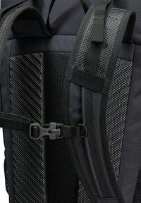 Zaino nero con spallacci in rete imbottita, dettagli testurizzati e una fibbia in plastica. Presenta un design snello e un tessuto resistente.