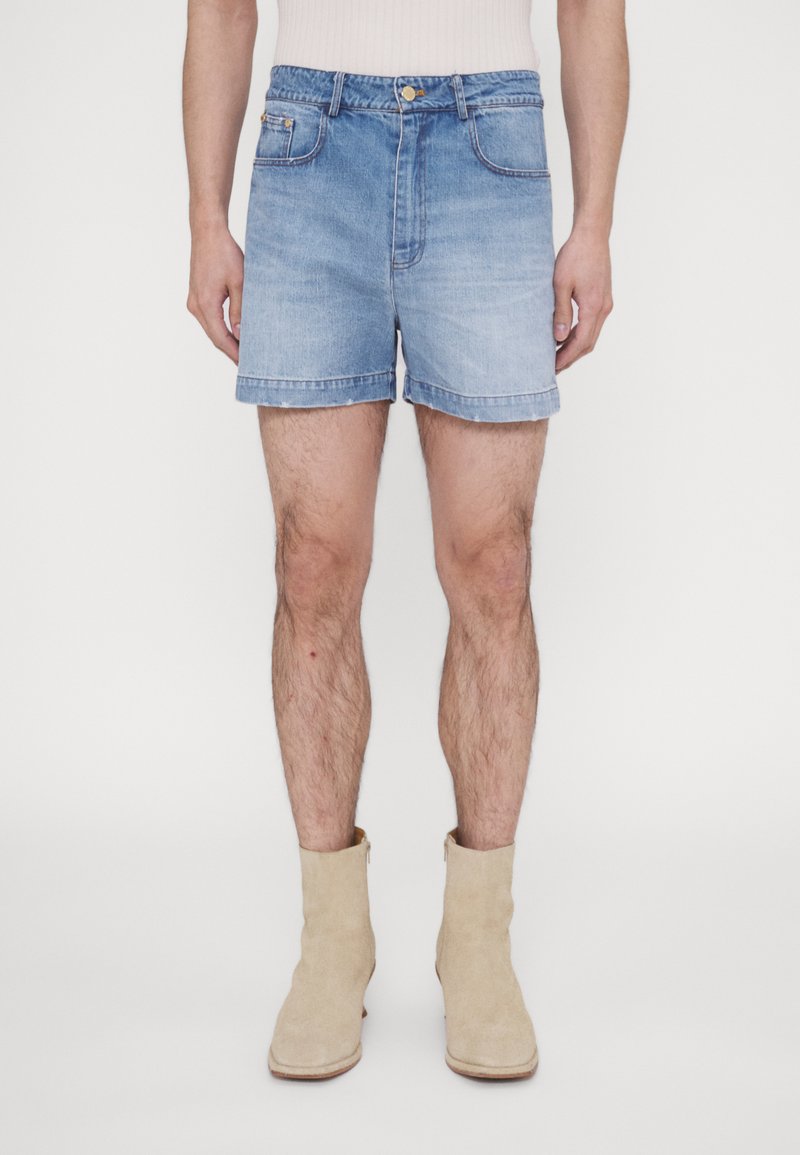 Shorts en denim bleu clair avec un effet délavé, possédant une fermeture éclair et un bouton, quatre poches et une coupe droite jusqu'au genou.