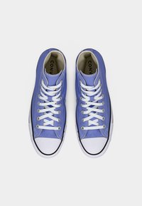 Πάνινα ψηλά sneakers σε ανοιχτό μπλε με λευκά κορδόνια, λαστιχένια μύτη και μαύρη επένδυση, με κυκλικό λογότυπο στο πλάι.