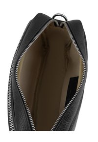 Bolso de cuero negro con un exterior texturizado, que cuenta con una cremallera plateada y un forro interior beige con dos bolsillos deslizantes. Vista abierta.