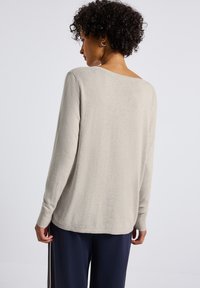Lichtgrijze lange mouwen sweater met een brede halslijn, ribgebreide manchetten en een relaxte fit. Zachte textuur, gladde afwerking en iets verlaagde schoudernaden.