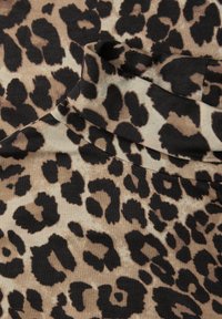 Leopardprintstof med store sorte pletter på en beige baggrund, med en blød, struktureret overflade og en let strækbarhed.