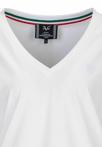 Witte V-hals T-shirt van zachte katoen met een subtiele schildlogo. Heeft een gekleurde gestreepte halsband in rood, wit en groen.
