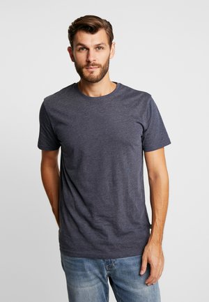 T-shirt gris foncé à manches courtes en tissu léger et doux, avec un col rond, une texture lisse et un design épuré. Porté avec un jean bleu clair.
