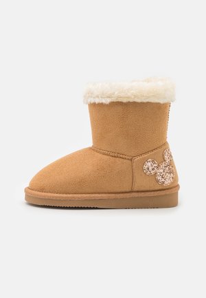 Botte d'hiver en suède couleur fauve avec un revers blanc duveteux et un visage pailleté de Mickey Mouse sur le côté du talon.