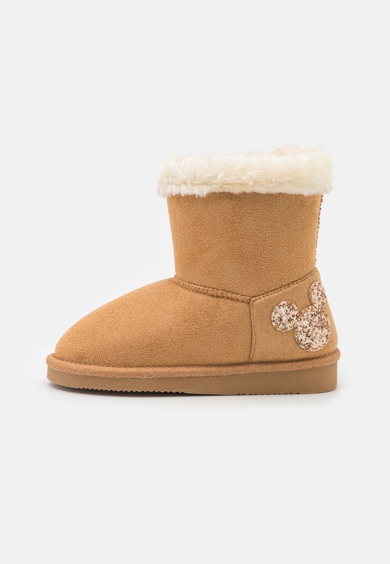 Botte d'hiver en suède couleur fauve avec un revers blanc duveteux et un visage pailleté de Mickey Mouse sur le côté du talon.