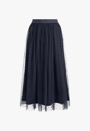 Jupe midi noire avec taille froncée, superposée d'un tulle transparent à pois, créant une silhouette texturée et fluide.