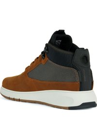 Zapatilla alta de ante marrón y malla negra con suela blanca y acentos moldeados. Presenta una punta redondeada y un diseño de cordones seguro.