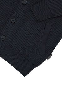 Ciemnoniebieski sweter z dzianiny o prążkowanej fakturze, z sześcioma czarnymi guzikami, kieszenią i małą metką z logo po boku.