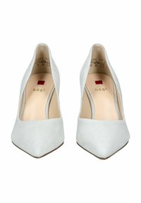 Tacones altos de gamuza gris claro con punta afilada, diseño minimalista y una fina correa en el tobillo. Presenta un pequeño logo y una plantilla suave.