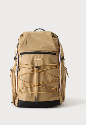 Tan backpack with black bottom, front zipper pocket, yellow lace crisscross, and K-Way logo on the front.