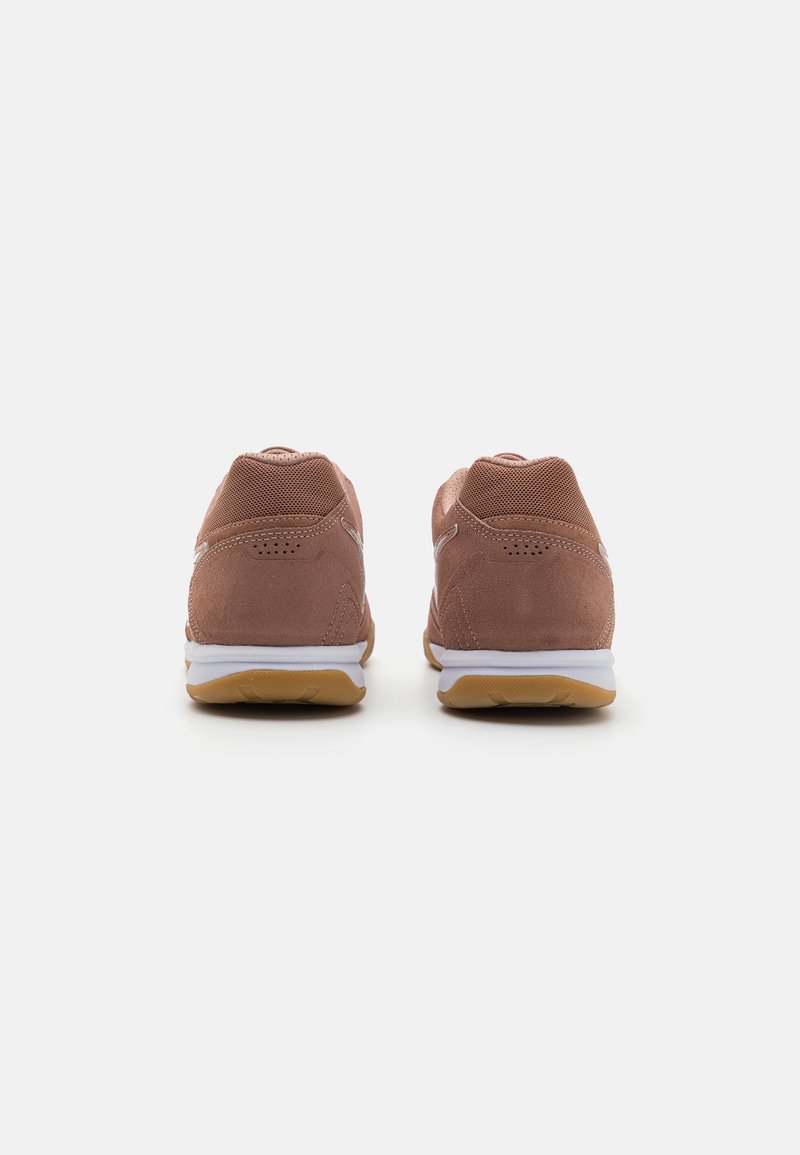 Zapatillas deportivas de ante marrón con acentos de malla y suelas blancas, con forma redondeada y detalles texturizados en el talón.