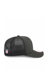 Schwarze Trucker-Cap mit einer soliden Vorderseite, Mesh-Rücken, gebogenem Schirm und NFL-Logo-Etikett auf der linken Seite. Robustes Material, modernes Design.