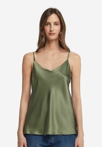 Olivgrön satinlinne med tunna axelband och V-ringning. Slät textur med mjukt fall. Bärs tillsammans med avslappnade denimbyxor.