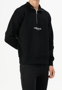 Czarna bluza z półzamkowym kołnierzem, z białym logo tekstowym na przodzie. Wykonana z materiału dresowego, luźny krój.
