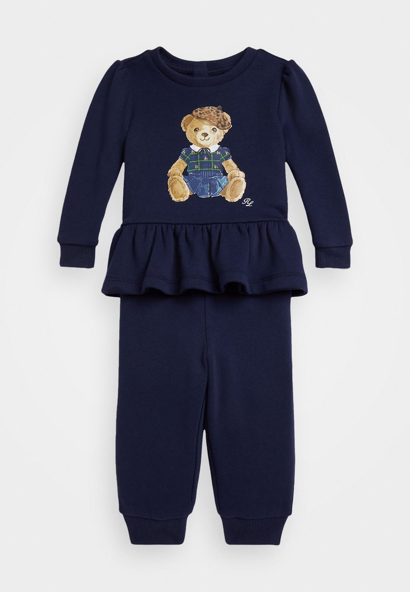 Námořnická modrá dvoudílná souprava skládající se z topu s peplum pasem a designem medvídka, spárovaná s odpovídajícími tepláky a žebrovanými manžetami.