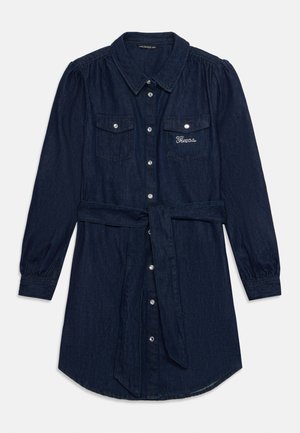 Vestido camisero de denim en azul oscuro con botones en el frente, dos bolsillos en el pecho y un cinturón anudado. Presenta mangas abullonadas y detalle de logotipo bordado.