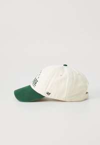 Crème katoenen baseballpet met groene klep, voorzien van opdruk van tekst en logo aan de voorkant. Verstelbare strap aan de achterkant.