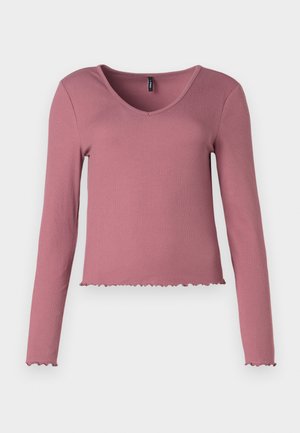 Długi rękaw, prążkowany top w odcieniu przykurzonego różu, z dekoltem w kształcie litery V i falbaniastym wykończeniem. Gładka tekstura, dopasowany krój i minimalne detale.