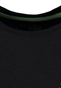 Zbliżenie na dwa nałożone dekolty koszulek, zewnętrzna czarna o teksturowanej tkaninie, wewnętrzna zielona z gładkim wykończeniem.