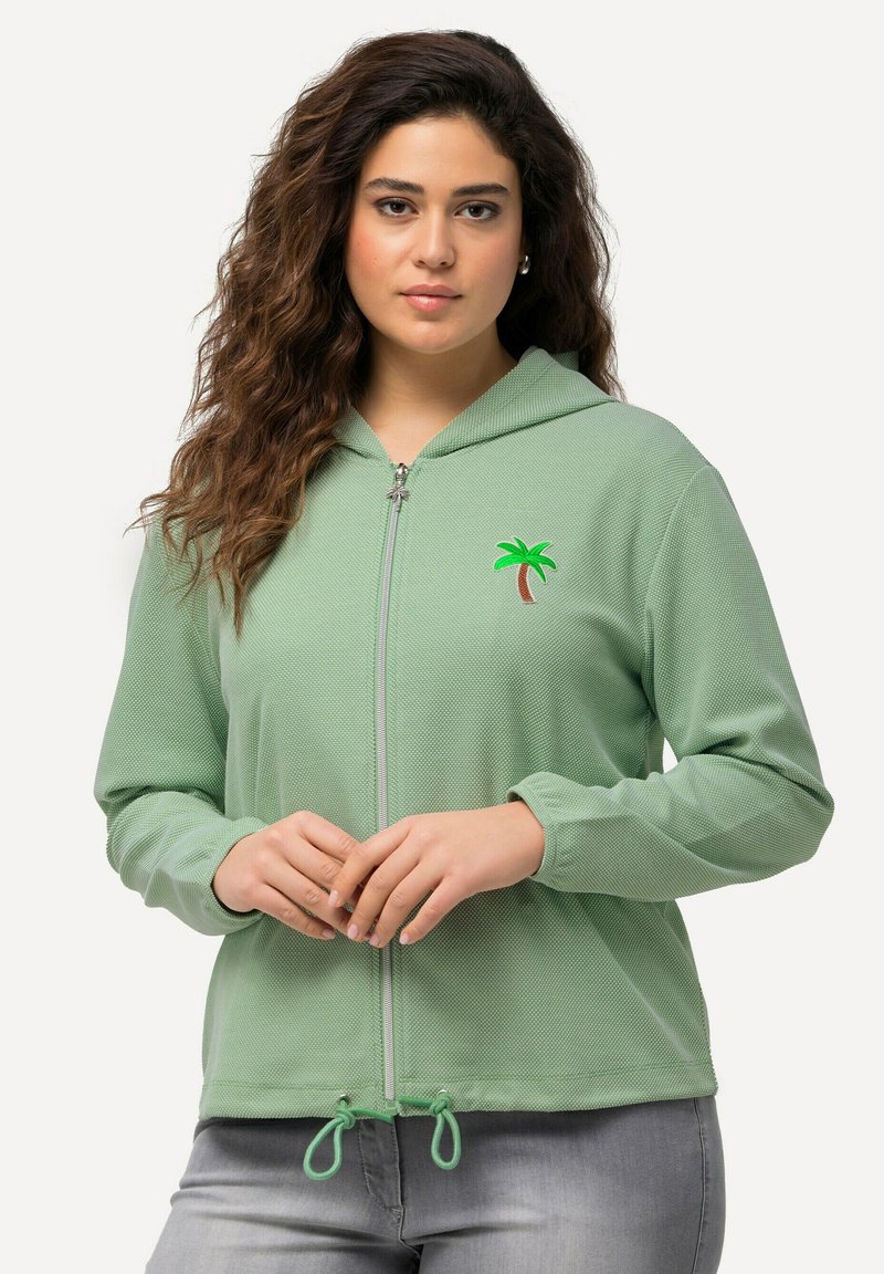 Hoodie vert zippé avec broderie de palmier, tissu texturé, manches longues, ourlet à cordon et fermeture éclair.