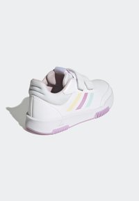 Bílé sportovní boty s texturovaným koženým svrškem, vybavené pastelovými pruhy (žlutá, růžová, tyrkysová) a fialovou gumovou podrážkou.