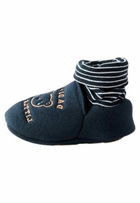 Marinblå stövlar i tyg med randig ankelflik, prydda med en björndesign och broderad text som säger "liten." Mjukt, varmt material med en flexibel sula.