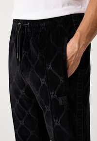 HUGO DISLACO - Pantalon de survêtement - black