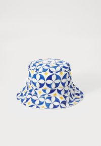 Bucket hat med et mønster af blå, hvide og gule blomster og diamanter, lavet af stof med en glat tekstur.