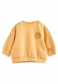 Gul sweatshirt i mjukt material, med rund halsringning, puffärmar, ribbad mudd och en broderad lejonansikte framtill.