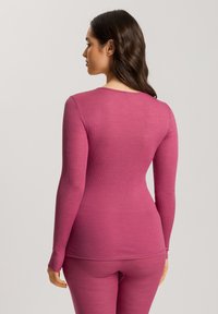 Top a maniche lunghe in tessuto a coste, con collo rotondo e design aderente di un colore magenta solido, abbinato a pantaloni coordinati.