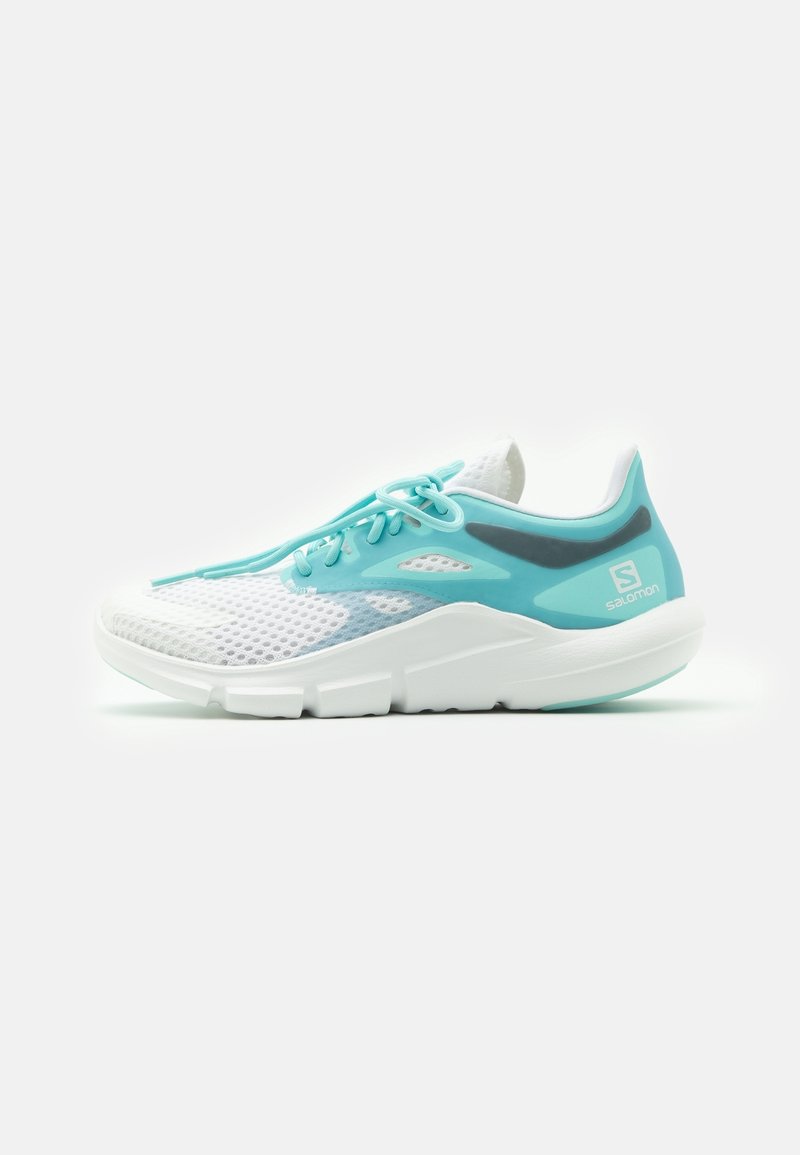 Scarpe sportive bianche con tomaia in rete, dettagli turchesi e una suola bianca spessa. Presentano un branding minimale e un design snello.