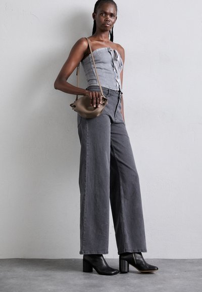 Denim tube top with front buttons, paired with high-waisted gray wide-leg pants and black heeled ankle boots. Includes a small brown bag.