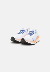 Weiße Sportschuhe mit blauen Schnürsenkeln. Obermaterial aus Mesh, orangefarbene Akzentuierung an der Zwischensohle und strukturiertem schwarzen Gummi-Außensohle. Leichtes Design.