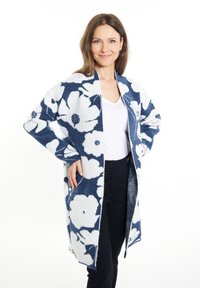 Cardigan con motivo floreale in blu navy e bianco, realizzato in materiale morbido. Design aperto con due tasche laterali e vestibilità comoda.