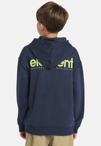 Marinblå huvtröja med stort grönt "element"-logotyp på ryggen, ribbade muddar och nederkant, samt en avslappnad passform. Mjuk bomullsblandning.