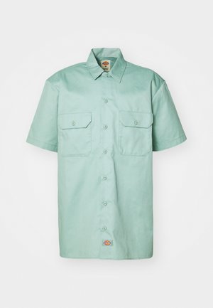 Chemise à manches courtes de couleur vert menthe en coton. Dotée d'une fermeture à boutons sur le devant, de deux poches poitrine et d'une étiquette de logo près de l'ourlet.